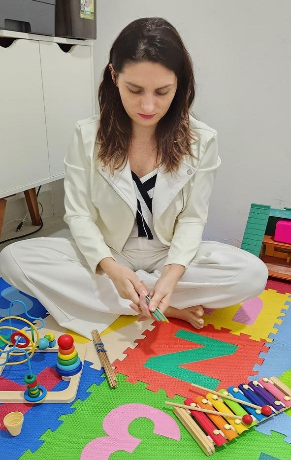 Renata Allan, psicopedagoga, em atendimento infantil com materiais educativos