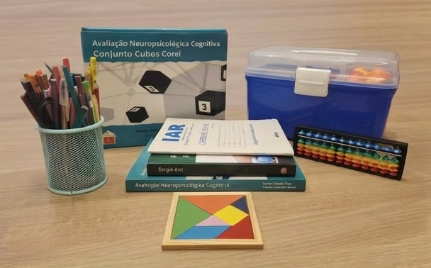 mesa de Renata Allan, contendo diversos materiais a serem utilizados em avaliações e atendimentos